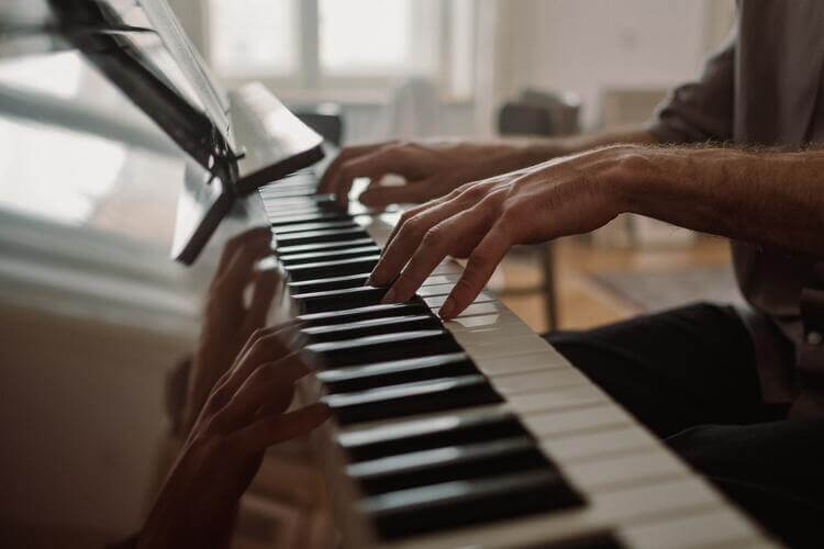 a left-handed pianist is playing the piano 