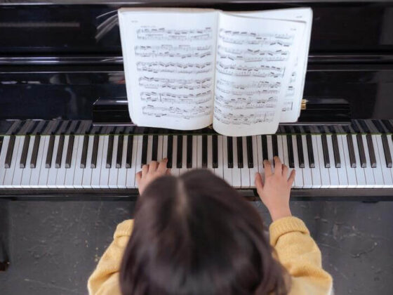 a pianist is playing the piano with a sheet music book open