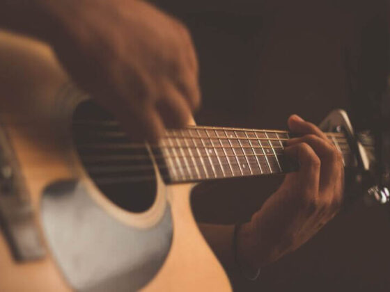 a guitarist is playing fingerstyle guitar