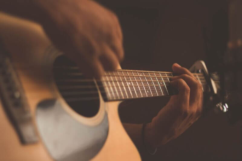 a guitarist is playing fingerstyle guitar