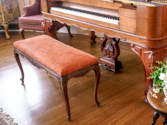 a piano practice area with an orange piano bench cushion