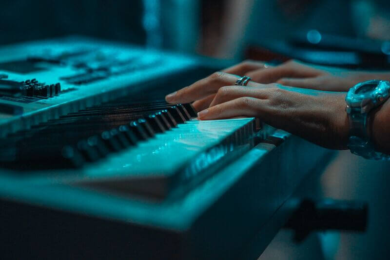 a pianist is playing on a cheap touch sensitive keyboard